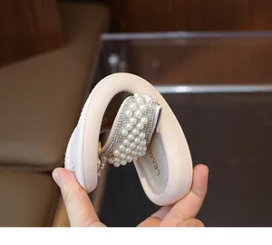 Primer plano de la suela blanda y flexible de las chanclas de niña decoradas con perlas