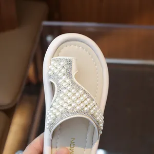 Elegantes sandalias de dedo para niña con adornos de perlas y pedrería, color crema.