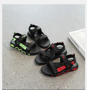 Close-up of lightweight children's summer sandals in red and green accents on grey floor