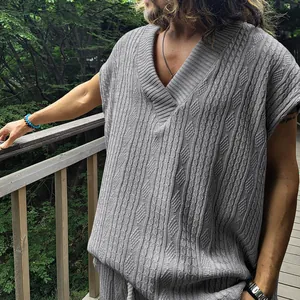 Détail rapproché d'un gilet sans manches gris à col en V avec motifs jacquard complexes
