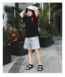 Full view of children's lightweight black sports sandals worn by a boy in an outdoor garden