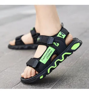 Close-up detail of boys' black sandals with neon green straps and soft sole