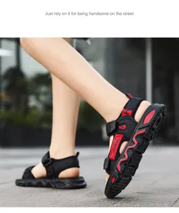Close-up view of boy's black and red summer sandals with flexible soft sole on pavement