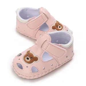 Detalle de sandalias rosas para bebé con bordado de oso y diseño hueco transpirable