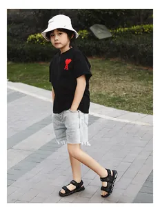 Boy wearing black sporty beach sandals with adjustable straps in park setting.