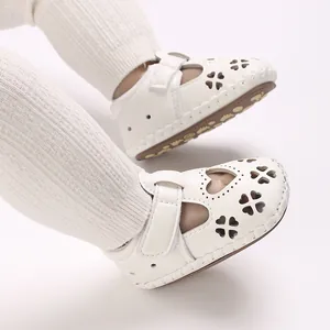Detailopname van witte baby sandalen van PU-leer met hartuitsparingen en zachte zolen