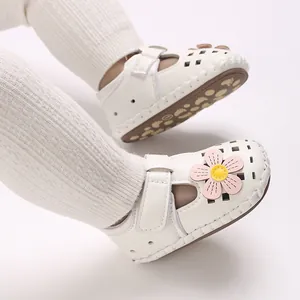 Nahaufnahme weißer Baby-Sandalen mit rosa Blumen und Klettverschluss