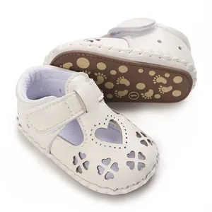 Detailweergave van witte babysandalen met hartvormige uitsnijdingen en zachte printzool