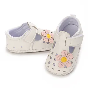 Nahaufnahme der weißen Babylauflernschuhe mit rosa Blumen und Lochmuster-Design