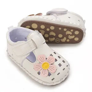 Detaillierte Nahaufnahme von weißen Baby-Sandalen mit süßer rosa Blumendekoration