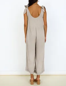 Back view of a chic oatmeal wide-leg jumpsuit with elegant tie-shoulders and a deep U-neck design.