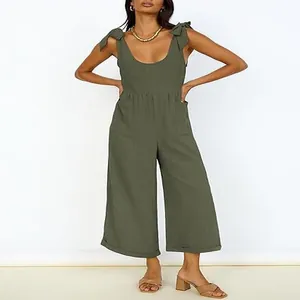 Detail view of olive green wide-leg jumpsuit with tie-shoulder straps and patch pockets