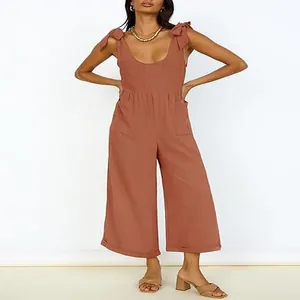 Detailed view of women's terracotta wide-leg jumpsuit with U-neck and tie-up shoulder straps