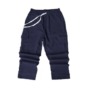Dettaglio pantaloni cargo in velluto a coste blu navy con coulisse bianca.