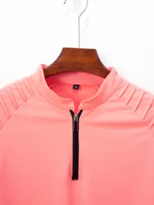 Detail of salmon pink men's polo shirt with half-zipper and pleated shoulder