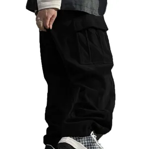 Close-up of black corduroy cargo pants showing side pocket detail and texture.