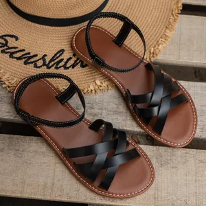 Nahaufnahme schwarzer Riemchensandalen mit elastischem Knöchelriemen für den Sommerstrand