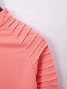 Detailed close-up showing the pleated shoulder design of a men's coral pink polo shirt