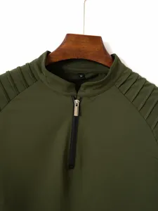Detailed view of army green men's polo shirt with quarter-zip and pleated shoulder texture