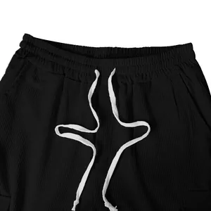 Dettaglio ravvicinato della vita dei pantaloni da uomo in velluto nero con coulisse bianca