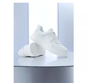 Professioneel aanzicht van witte platform sneakers van leer met ademende stiksels