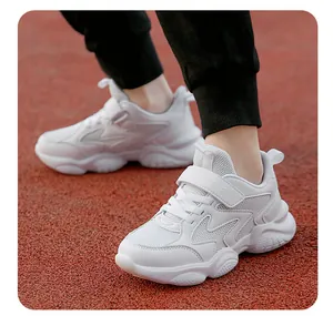 Close-up view of white breathable children's sneakers on a red outdoor running track