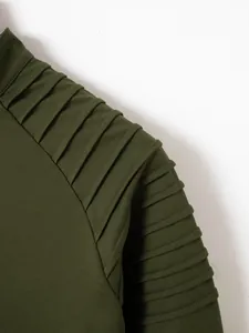 Close-up detail of the pleated shoulder and sleeve on an olive green men's polo shirt