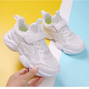 Close-up of white children's running shoes with breathable mesh panels and Velcro strap closure.