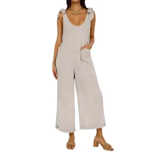 Solid color wide-leg jumpsuit with tie-shoulders, deep U-neck, and functional pockets.