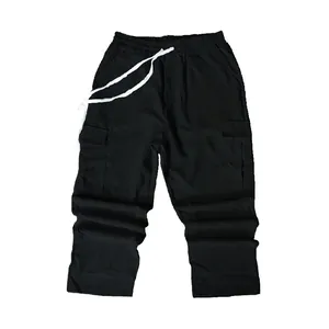 Close-up of black corduroy men's cargo pants featuring white drawstring and side pockets