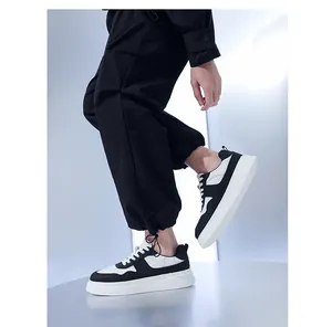 Zijaanzicht van zwart-witte herensneakers met dikke zool gedragen met een cargobroek