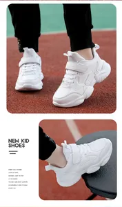 Detailed view of breathable white kids sneakers on a red running track