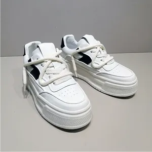 Λεπτομερής προβολή λευκών sneakers πλατφόρμας με χοντρά κορδόνια και μαύρες λεπτομέρειες