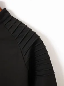 Close-up detail showing the unique pleated shoulder design on a black men's long sleeve polo shirt