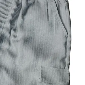 Close-up of light blue corduroy pants showing fabric texture and cargo pocket detail.