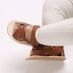 Close-up van bruine babyloopschoentjes met zachte zolen en een klittenbandsluiting voor baby's.
