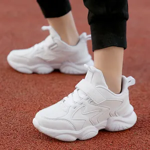 Lightweight breathable white kids sports shoes displayed on a red outdoor athletic track.