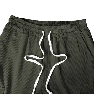 Dettaglio macro dei pantaloni casual da uomo in velluto a coste con cordoncino bianco robusto.