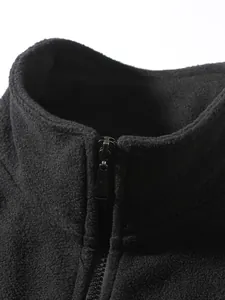 Nahaufnahme einer schwarzen Herren-Fleecejacke mit Stehkragen und Reißverschluss.