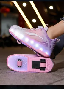 Close-up of pink children's roller shoes with dual wheels and glowing LED lights