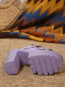 Close-up of the textured rubber sole and block heel on a purple platform sandal