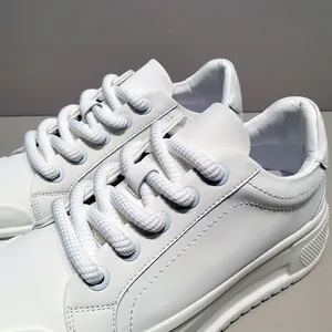 Λεπτομέρεια από λευκά chunky bread sneakers με χοντρή σόλα και πλεκτά κορδόνια.
