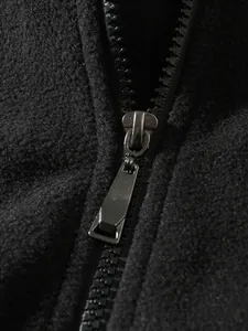 Detailaufnahme des stabilen Metallreißverschlusses an einer schwarzen Fleecejacke