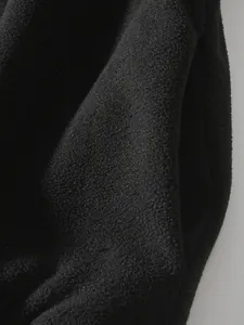 Hochwertiges Makro-Detail zeigt die weiche schwarze Polar-Fleece-Textur eines Sweatshirts