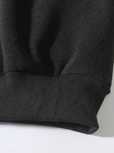 Nahaufnahme von schwarzem Polar-Fleece-Stoff und geripptem Bündchen am Herren-Sweatshirt