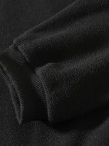Nahaufnahme des schwarzen Polar-Fleece-Ärmels mit elastischem Rippbündchen-Detail
