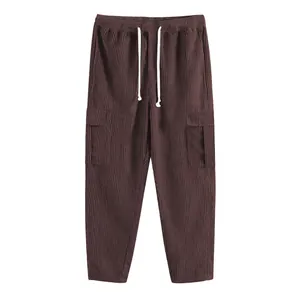 Dettaglio dei pantaloni cargo da uomo in velluto a coste marrone con coulisse e tasche laterali