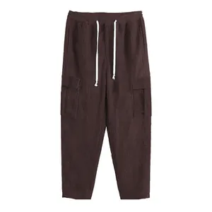 Close-up detail of men's dark brown corduroy cargo pants featuring a white drawstring.