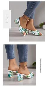 Dettaglio di eleganti sabot bianchi a fiori con punta quadrata e tacco largo sulla modella