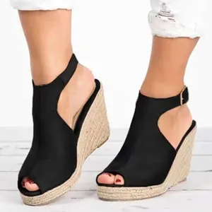 Gros plan de sandales compensées en daim noir avec plateforme en jute et bride